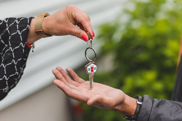  person passing a house key to another
